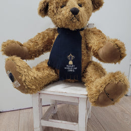 World Cup Rugby Bear. William by RUSS a special release for 2003. Limited to 5000 pieces worldwide. 50.8 cm fully jointed golden-brown bear with suedeen paw pads and blue scarf with Rugby World Cup Logo embroidery.

*Please note chair in photo is not included.