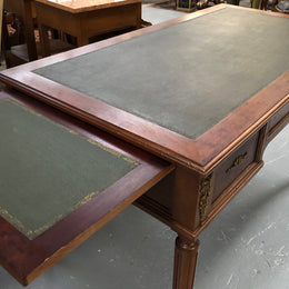 Lovely French Mahogany Louis XVI style leather top desk. With beautiful ormolu details and three drawers. There are also two slides on either side with tooled leather tops and in good original detailed condition.