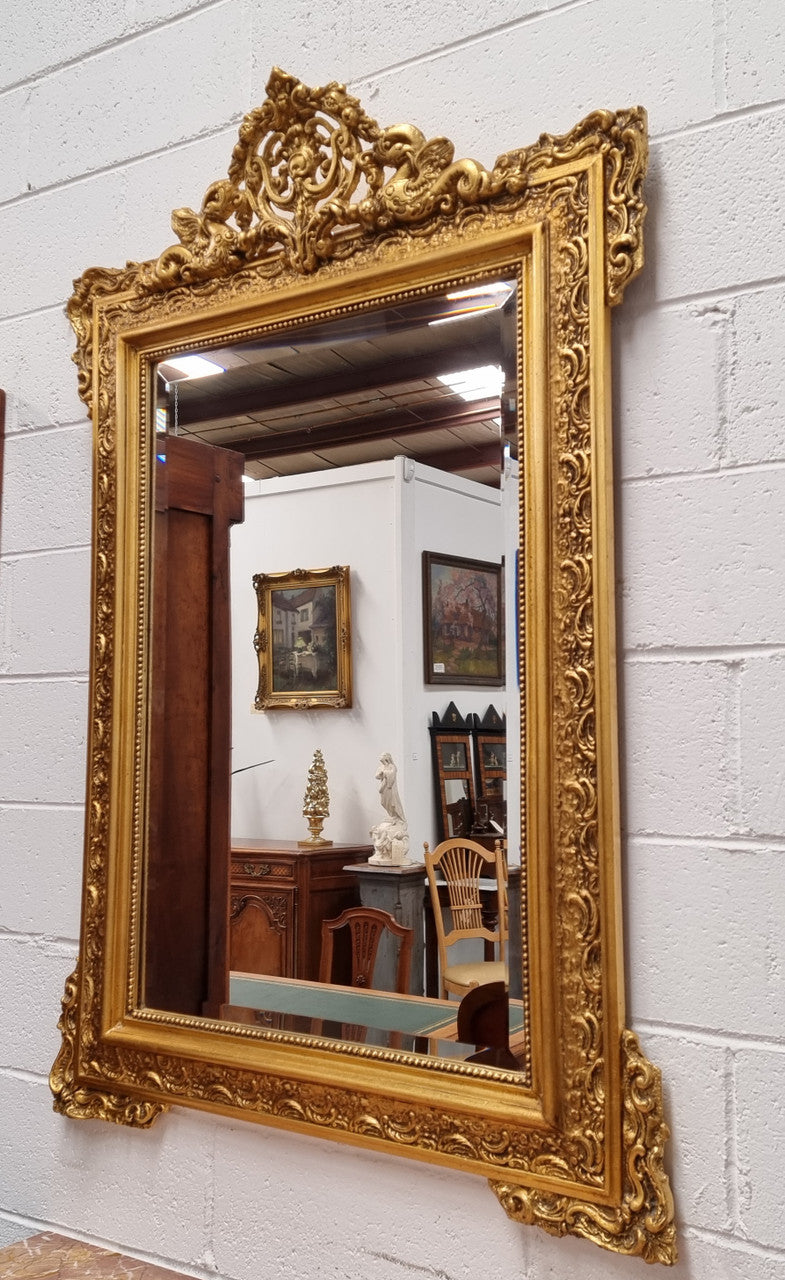 French ornate gilt framed wall mirror with bevelled mirror and decorated with water dragons. This has been sourced from France and is in good original condition.