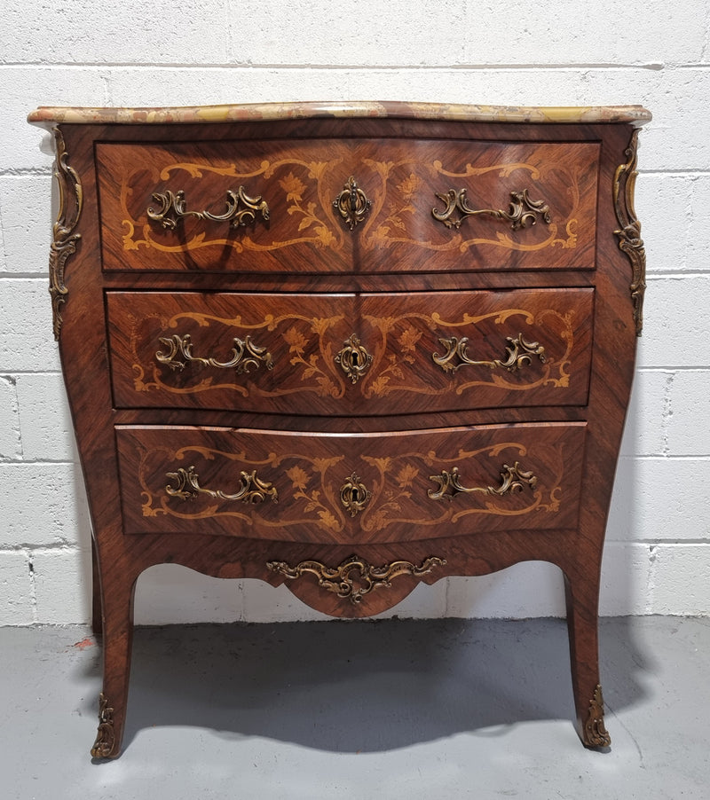 French Marquetry inlaid, three drawer commode with a lovely coloured marble top and beautiful ormolu mounts. This piece is in good original detailed condition.