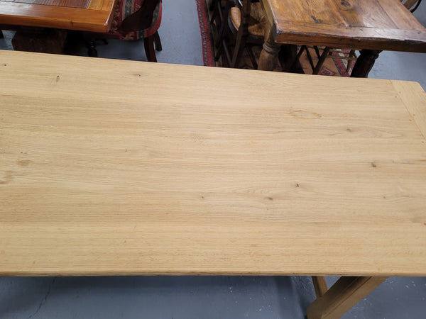 French raw Oak stretcher based refectory table. Features raw wood that could be used as is for a distressed look, or finished and waxed for a more refined look. Sourced from France and in good original condition.