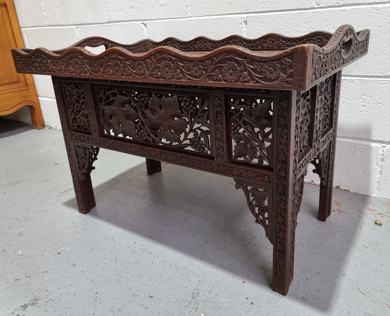 Anglo Indian folding occasional table with lift-up tray top. The tray has brass inlay and ornate carvings. The bottom of the table folds down and it is in good original condition.