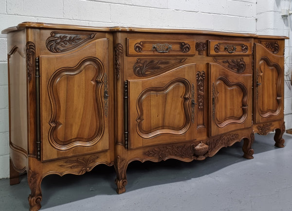 Amazing grand Walnut four door beautifully carved Louis XV style sideboard. Plenty of storage space with four doors all with adjustable shelves and two drawers. In good original detailed condition.