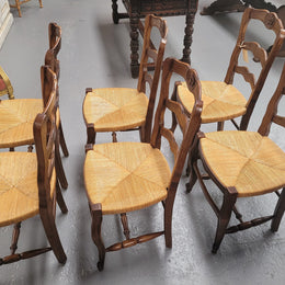 Set of six Louis XV style French Oak rush seat dining chairs. They are in good original detailed condition.