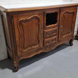 Lovely Louis XV style French Oak carved sideboard with two drawers and two cupboards for all your storage needs. It has a nice coloured marble top and in good original detailed condition.