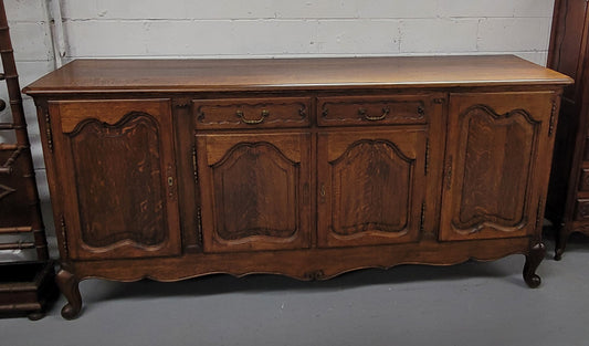 Louis XV style French Oak sideboard consisting of four doors and two drawers. It is in good restored condition.