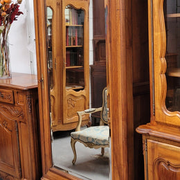 French Louis XV style Walnut armoire with single bevelled mirrored door. It has four adjustable shelves and a hidden exterior drawer at the bottom. It has been sourced from France and is in good original detailed condition.