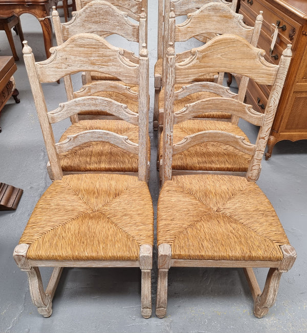 Rustic set of eight French limed rush seat dining chairs. They are very sturdy and solid. Wide sit making them comfortable to sit in and are in original condition.