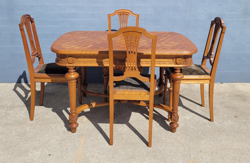 Beautiful carved French Oak dining table with a parquetry top and six matching upholstered chairs. All in good original detailed condition.