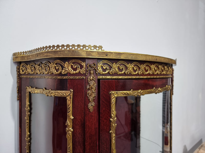 Louis XV style Walnut vitrine display cabinet with attractive ormolu mounts. Beautiful Maroon floral fabric backing with two glass shelves and cabriole legs with decorative ormolu mounts. In good original detailed condition.