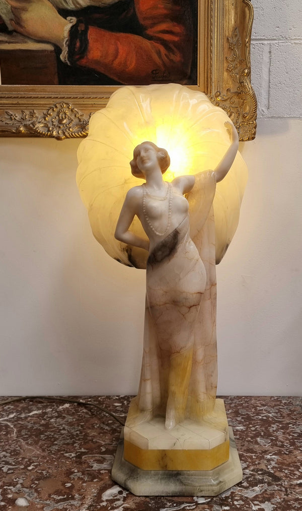 Monumental Art Deco alabaster and marble figural lamp modelled as a seductively dressed semi naked woman. In subtlety coloured diaphanous robes with a large clam shell light backdrop. Italian circa 1920's signed to base. This is a world class example of a true Art Deco sculpture lamp. It is in good original detailed condition, please view photos as they help form part of the description.