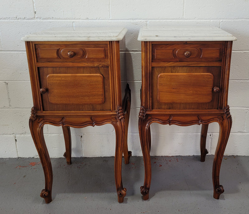 Pair of stunning Louis XV style French Walnut white marble top bedside cabinets. They have one drawer and a cupboard that is marble lined. The marble has been polished and they are in good original detailed condition.