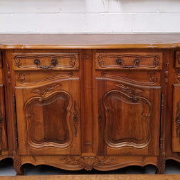 A Beautifully carved French Walnut Louis XV style four door sideboard. Plenty of storage space with four doors as well as four drawers. It is in good original detailed condition.
