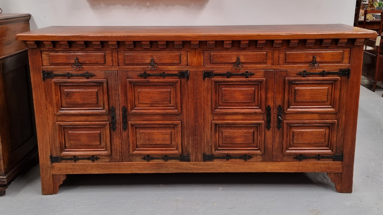 Large Rustic Oak Spanish style four door buffet with plenty of storage and fabulous hardware. It is in good  original detailed condition.