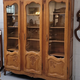 French Louis XV style light Oak three door bookcase with five fixed shelves. It has lovley glass doors and has been sourced from France. Is in good original detailed condition