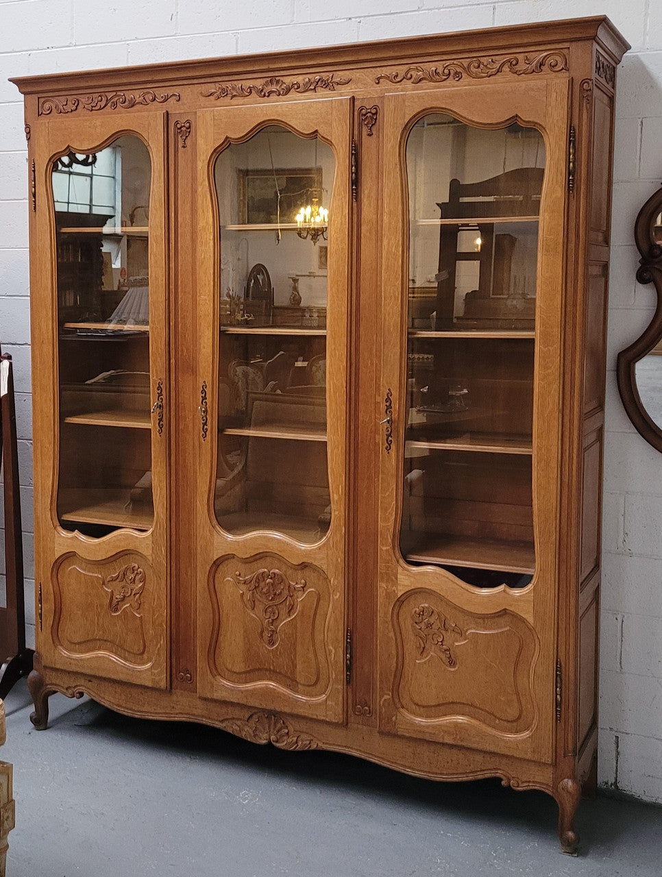 French Louis XV style light Oak three door bookcase with five fixed shelves. It has lovley glass doors and has been sourced from France. Is in good original detailed condition