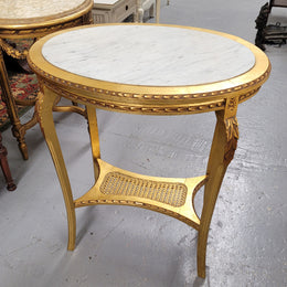 Impressive French oval Louis XVI style gilt and white marble topped two tier lamp/side table. It has been sourced from France and is in good original detailed condition.