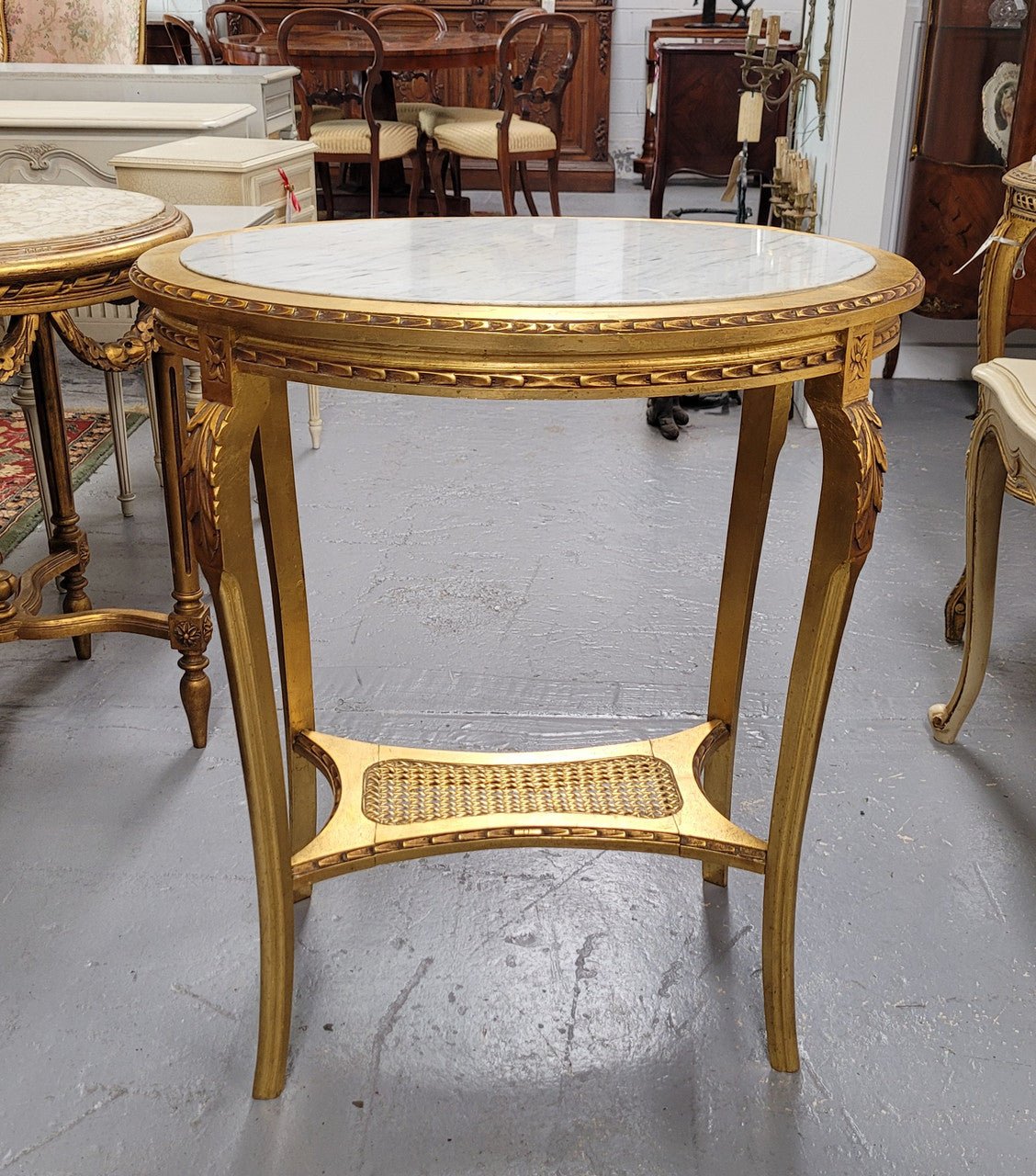 Impressive French oval Louis XVI style gilt and white marble topped two tier lamp/side table. It has been sourced from France and is in good original detailed condition.