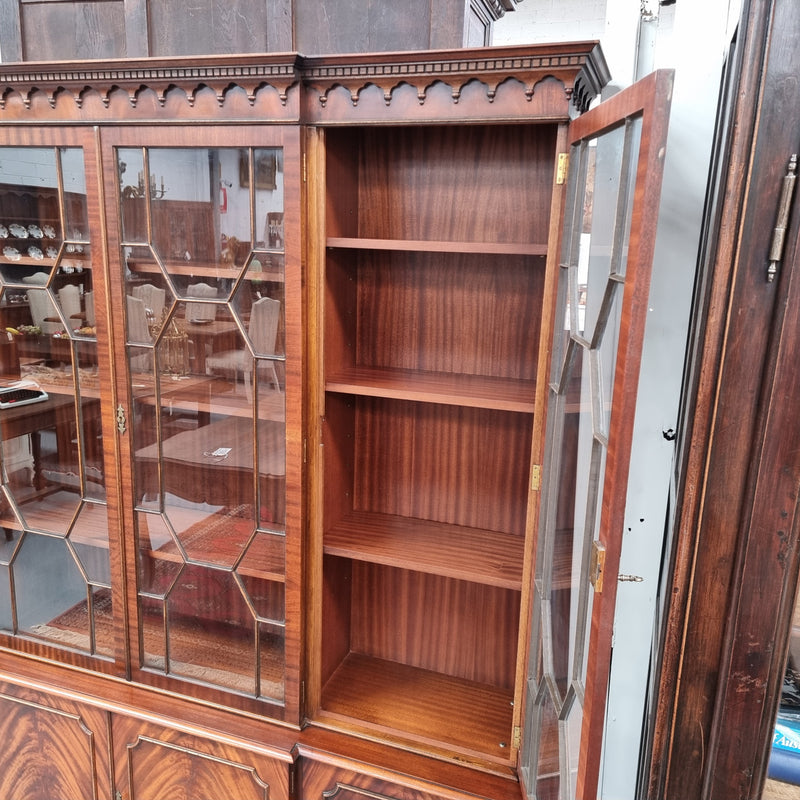 Georgian style Breakfront Flame Mahogany four door bookcase. A very impressive piece with plenty of storage and is of pleasing narrow proportions. It has been sourced locally and is in good original detailed condition.