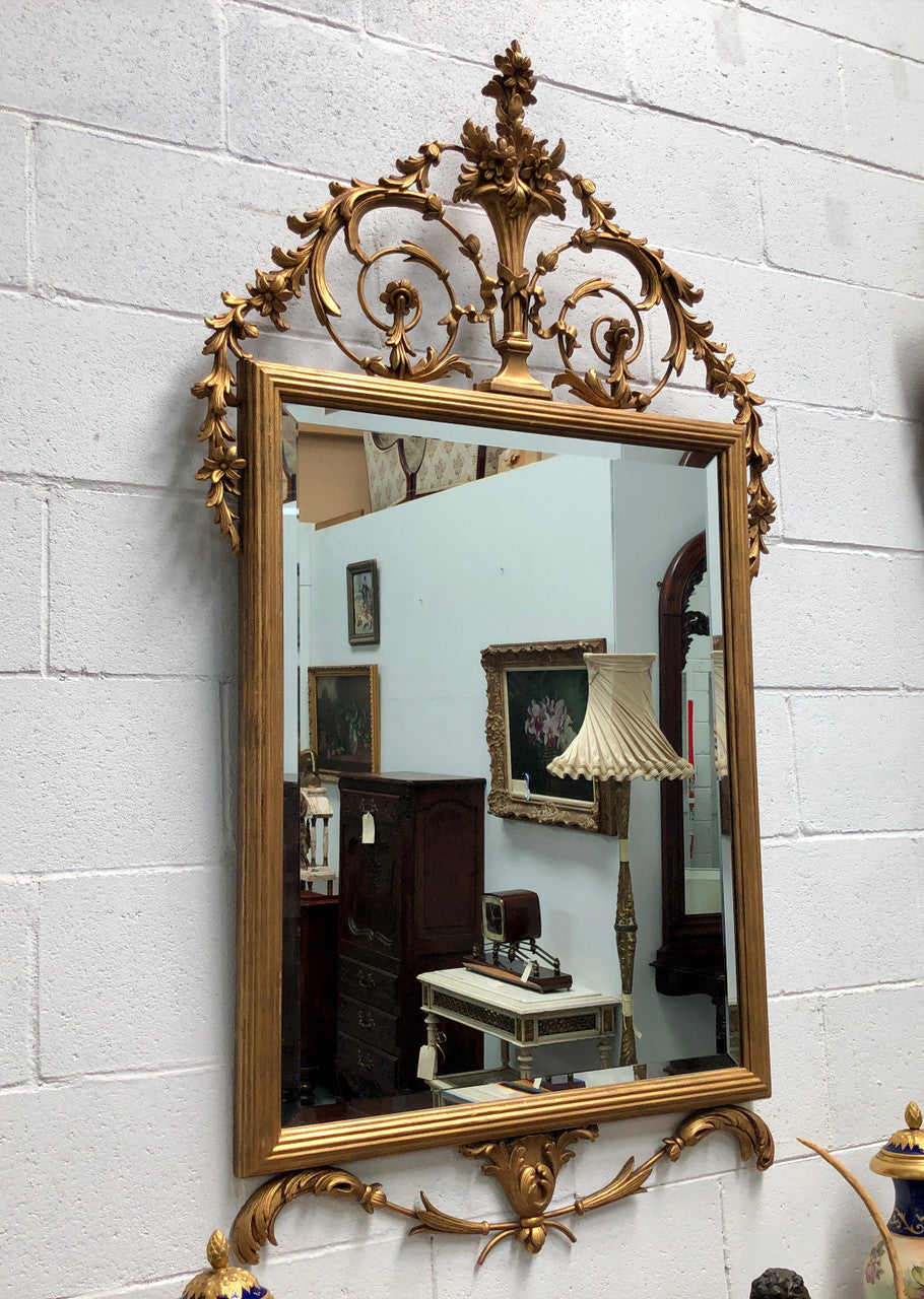 Mid 20th Century Italian gilt wood framed gold wall mirror. Highly decorative carving with a bevelled mirror. Is in good original condition.