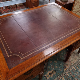 Substantial French Louis XVI style Oak partners desk. It has a beautiful leather top, two drawers on either side and decorative carvings throughout. Sourced from France and in good original detailed condition.