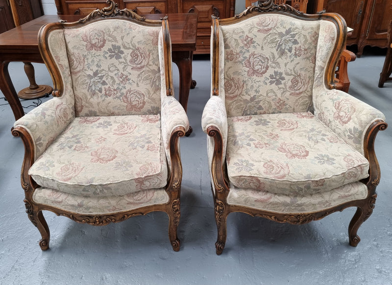 Lovely French pair of gilt and floral upholstered Bergere chairs with beautiful decorative carving. Fabric is in good original condition and chair has been detailed.