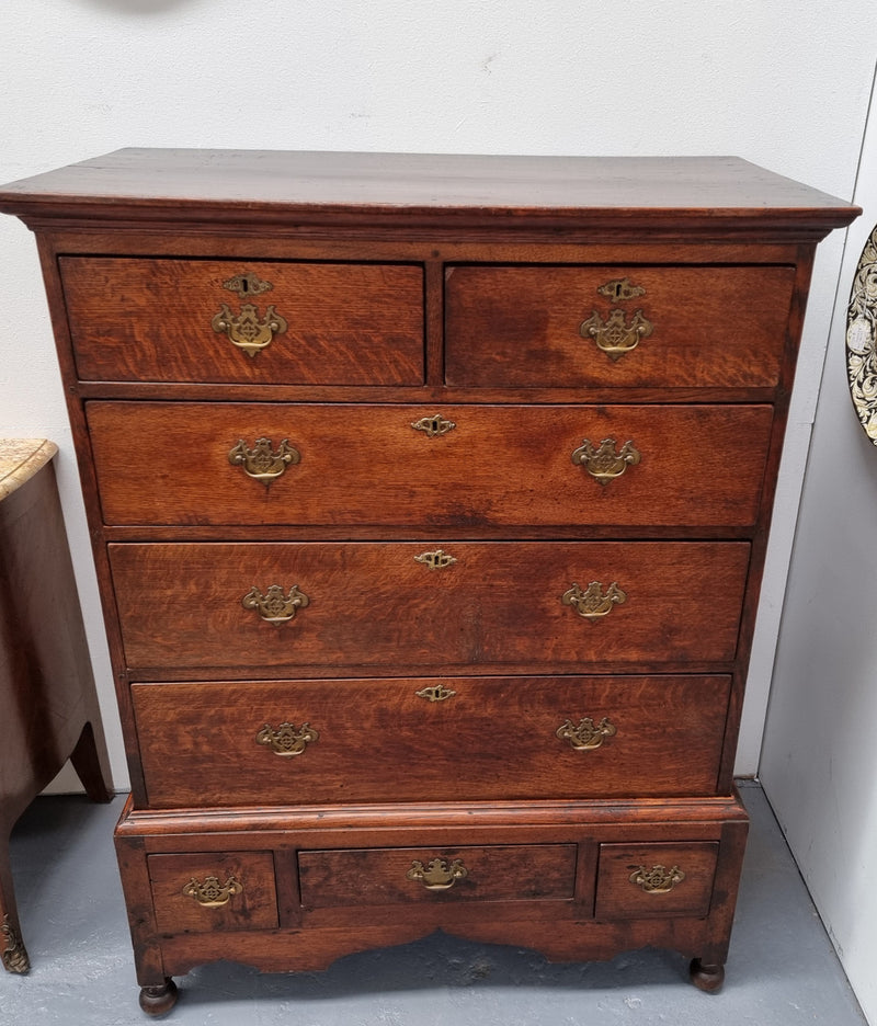 Early 19th Century English Oak chest on stand. It has been sourced in France and has plenty of storage space with eight drawers. In good original detailed condition.