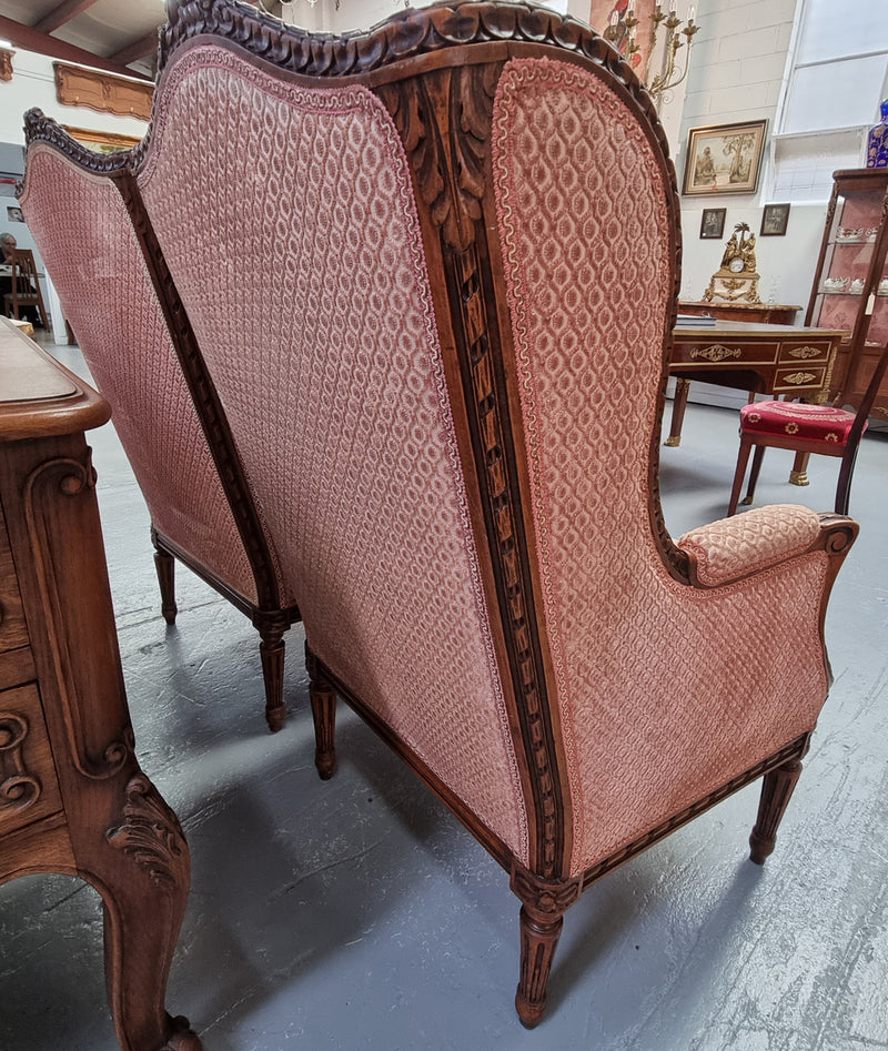 Lovely pair of  French Louis XVI style Walnut, upholstered Bergere chairs with beautiful carving and are in good original detailed condition.