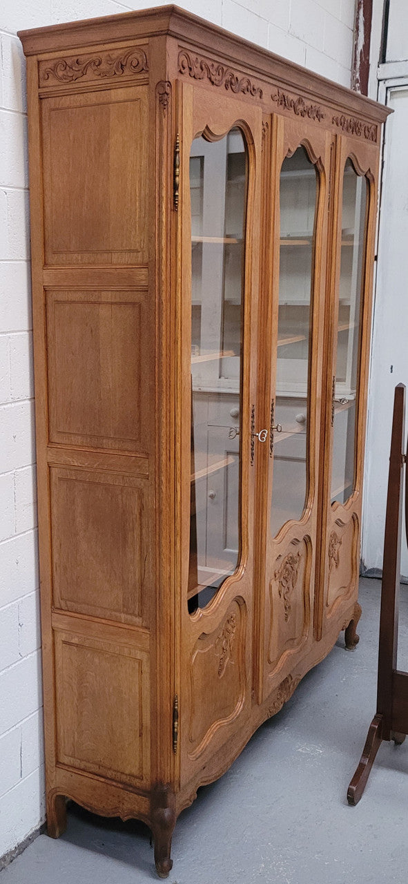 French Louis XV style light Oak three door bookcase with five fixed shelves. It has lovley glass doors and has been sourced from France. Is in good original detailed condition