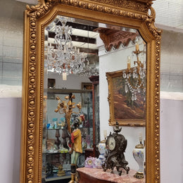 A stunning Napoleon III gilt mantle mirror with its original mirror. The top of the mirror is decorated with a beautiful laurel wreath and detailed decorative carving throughout. It is in good original condition with the bevelled mirror showing natural aging please view photo's.