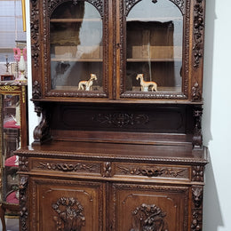Grand French Oak Gothic style buffet with amazing detailed carvings. This stunning buffet has a display section at the top with two adjustable shelves, two drawers in the middle with elegantly carved handles and storage below with one fixed shelf. It is in good original detailed condition.