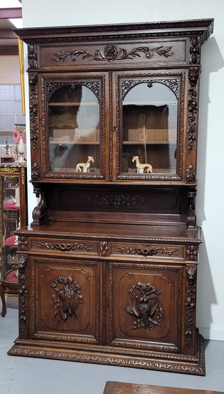 Grand French Oak Gothic style buffet with amazing detailed carvings. This stunning buffet has a display section at the top with two adjustable shelves, two drawers in the middle with elegantly carved handles and storage below with one fixed shelf. It is in good original detailed condition.