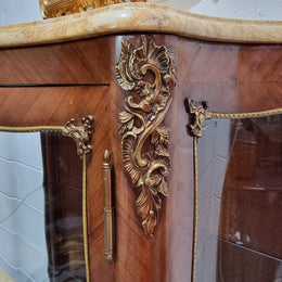 Grand French Walnut Louis XV style marble top vitrine. It has two glass shelfs and one mirrored shelf at the bottom and added storage at bottom. It is in good original detailed condition.