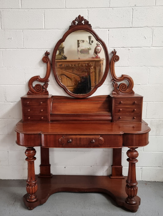 Victorian Mahogany duchess dressing table with tilt mirror on scrolled supports. It has seven trinket drawers and lift up storage. It is in good original condition and has been sourced locally.