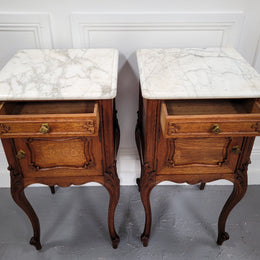Pair of French Antique Louis XV style Oak marble top night stands. They have beautiful carved cabriole legs and beautiful white marble along with a drawer and cupboard for storage space. They have been sourced from France and are in good original detailed condition.