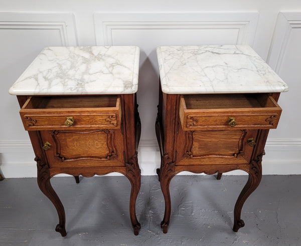 Pair of French Antique Louis XV style Oak marble top night stands. They have beautiful carved cabriole legs and beautiful white marble along with a drawer and cupboard for storage space. They have been sourced from France and are in good original detailed condition.