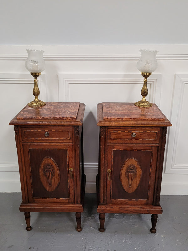Pair of French Art Deco Oak and rouge inset marble top bedside cabinets. They have one drawer and one cupboard with elegant carving on the door. They have been sourced from France and are in good original detailed condition.