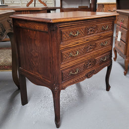 Rustic Louis XV style Oak petite three drawer chest featuring attractive carvings. It has been sourced locally and it is in good original detailed condition.