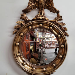 Vintage gilt framed convex mirror featuring carved eagle. It has been sourced from France and is in good original condition, please view photos as they help form part of the description.