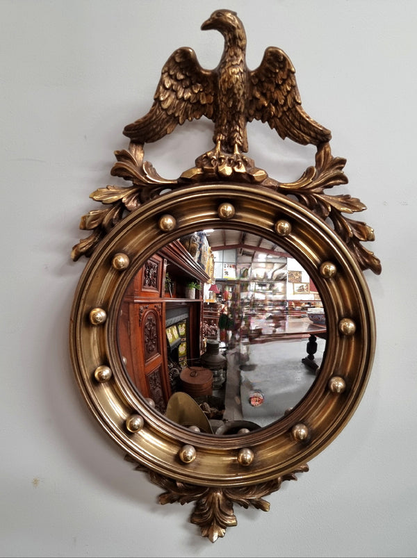 Vintage gilt framed convex mirror featuring carved eagle. It has been sourced from France and is in good original condition, please view photos as they help form part of the description.