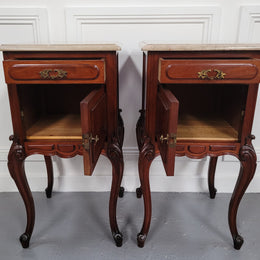 Pair of French Antiloopque Louis XV style Walnut and marble top bedsides. They have lovely carvings along with a drawer and cupboard space. They are in good original detailed condition and have been sourced from France