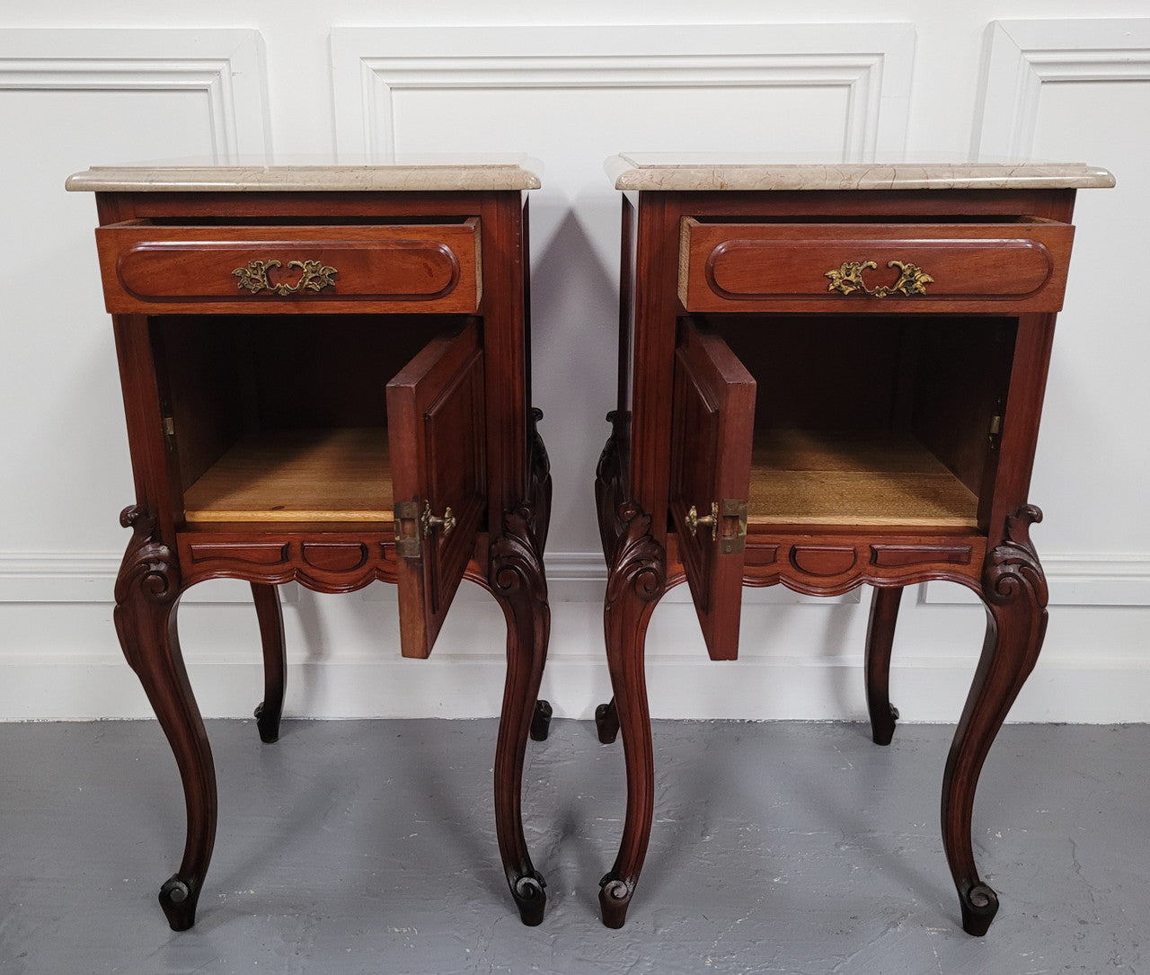 Pair of French Antiloopque Louis XV style Walnut and marble top bedsides. They have lovely carvings along with a drawer and cupboard space. They are in good original detailed condition and have been sourced from France