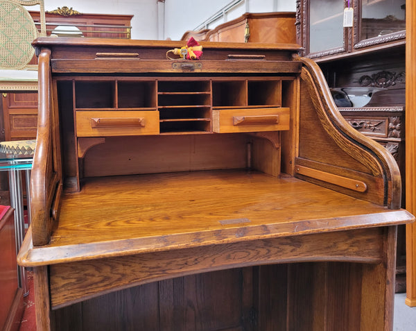 Charming petite English Oak fitted roll top desk. It has a very lovely fitted interior and a drawer at the front ideal for a unit or apartment. Sourced locally and in good original detailed condition.