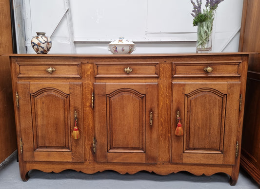 French Oak early 19th century three door buffet. It has a classic simple look and has three cupboards and three drawers. It is in good original detailed condition.