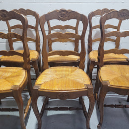 Set of six French Louis 15th style rush seated dining chairs. They are comfortable to sit in and are in original condition.