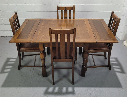 Fabulous small Oak extension table and four dining chairs. The table extends from a four seater to a six seater. The chairs have nice carvings and leather inset seats. They are in original detailed condition.