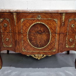 Stunning transitional French Marquetry inlaid marble top commode. It has lovely ormolu decorative mounts and an amazing thick marble top. Sourced from France and is in good original detailed condition.