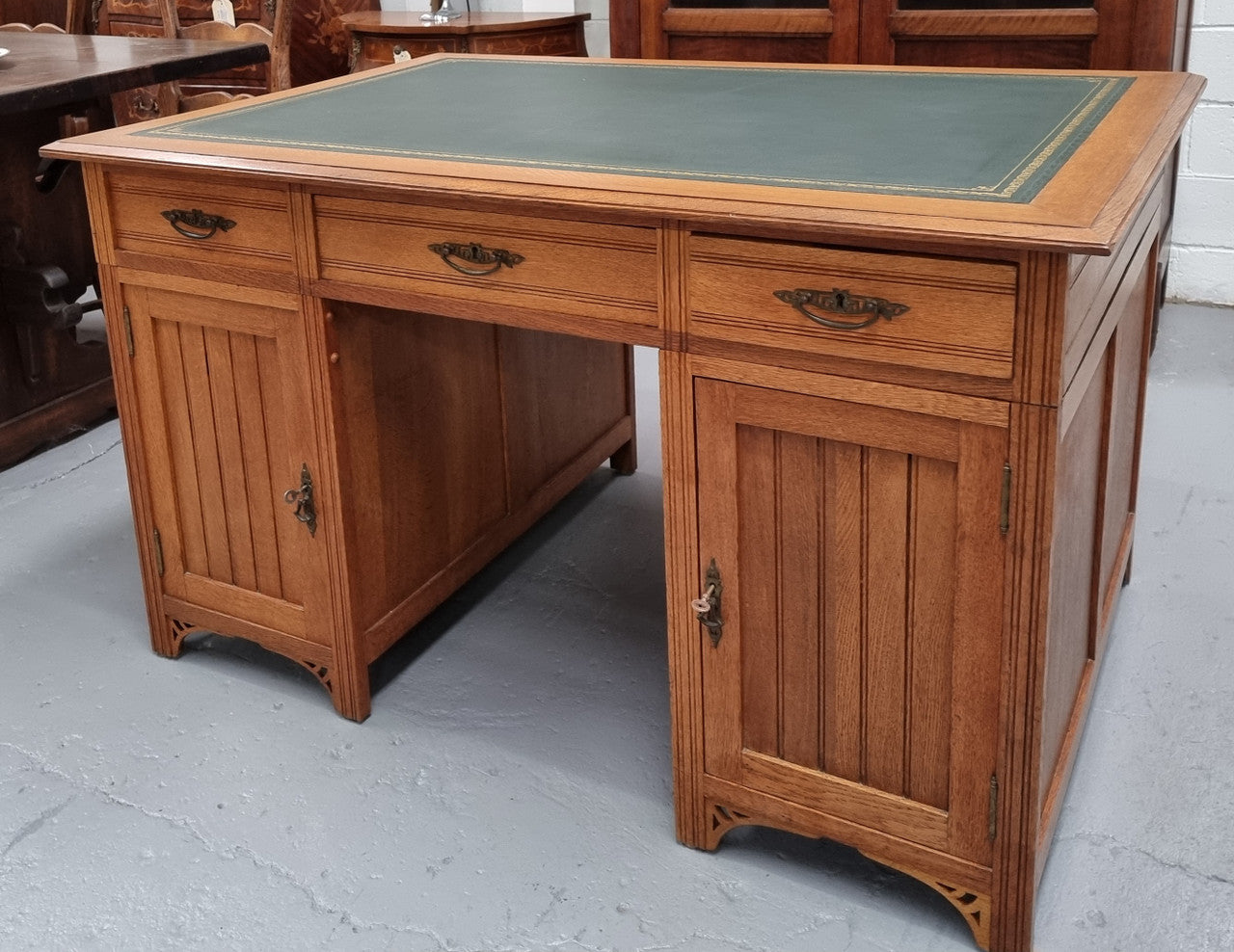 French Oak Art Deco full partners desk with leather top. Plenty of storage with both sides having three drawers at the top and two cupboards on both sides, one side has a filing section with three internal drawers and the other has a shelf on one side with three internal drawers as well. In good original detailed condition.