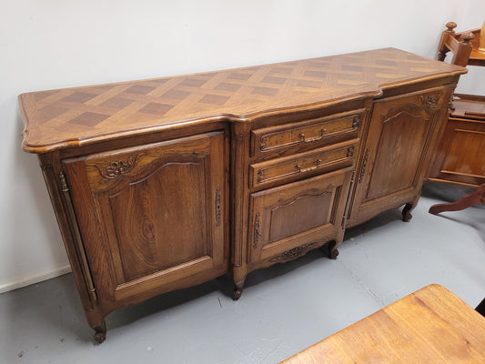 French Oak Louis XV style three door, two drawer, parquetry top sideboard. It has been sourced from France and is in good restored condition.