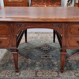 Substantial French Louis XVI style Oak partners desk. It has a beautiful leather top, two drawers on either side and decorative carvings throughout. Sourced from France and in good original detailed condition.
